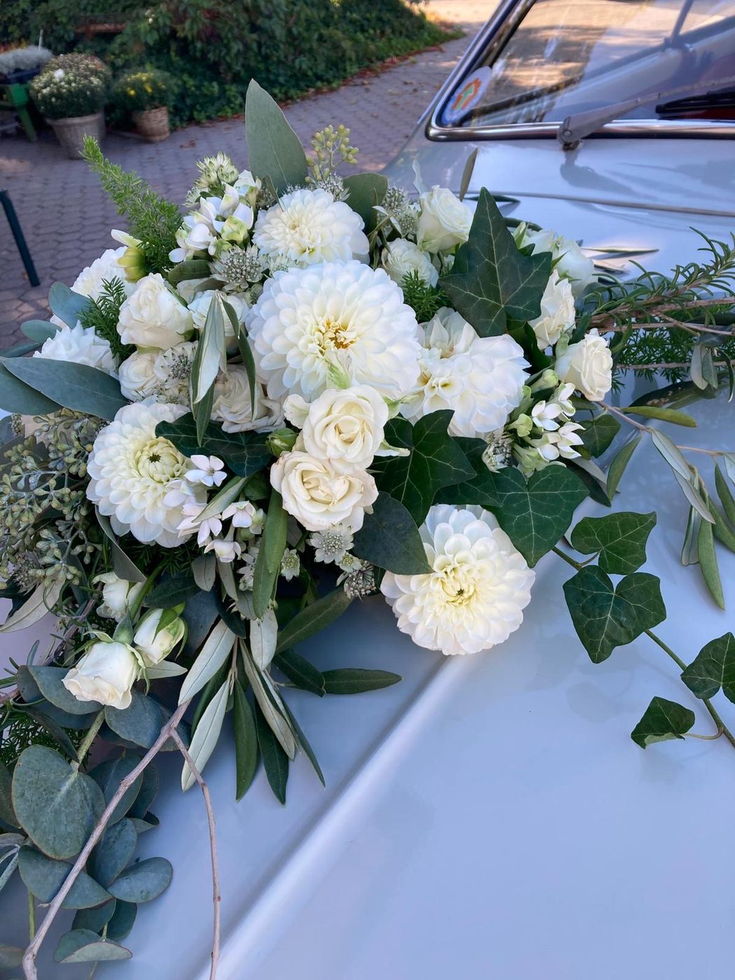 Weißer Autoschmuck aus Dahlien, Rosen und Efeu auf der Motorhaube