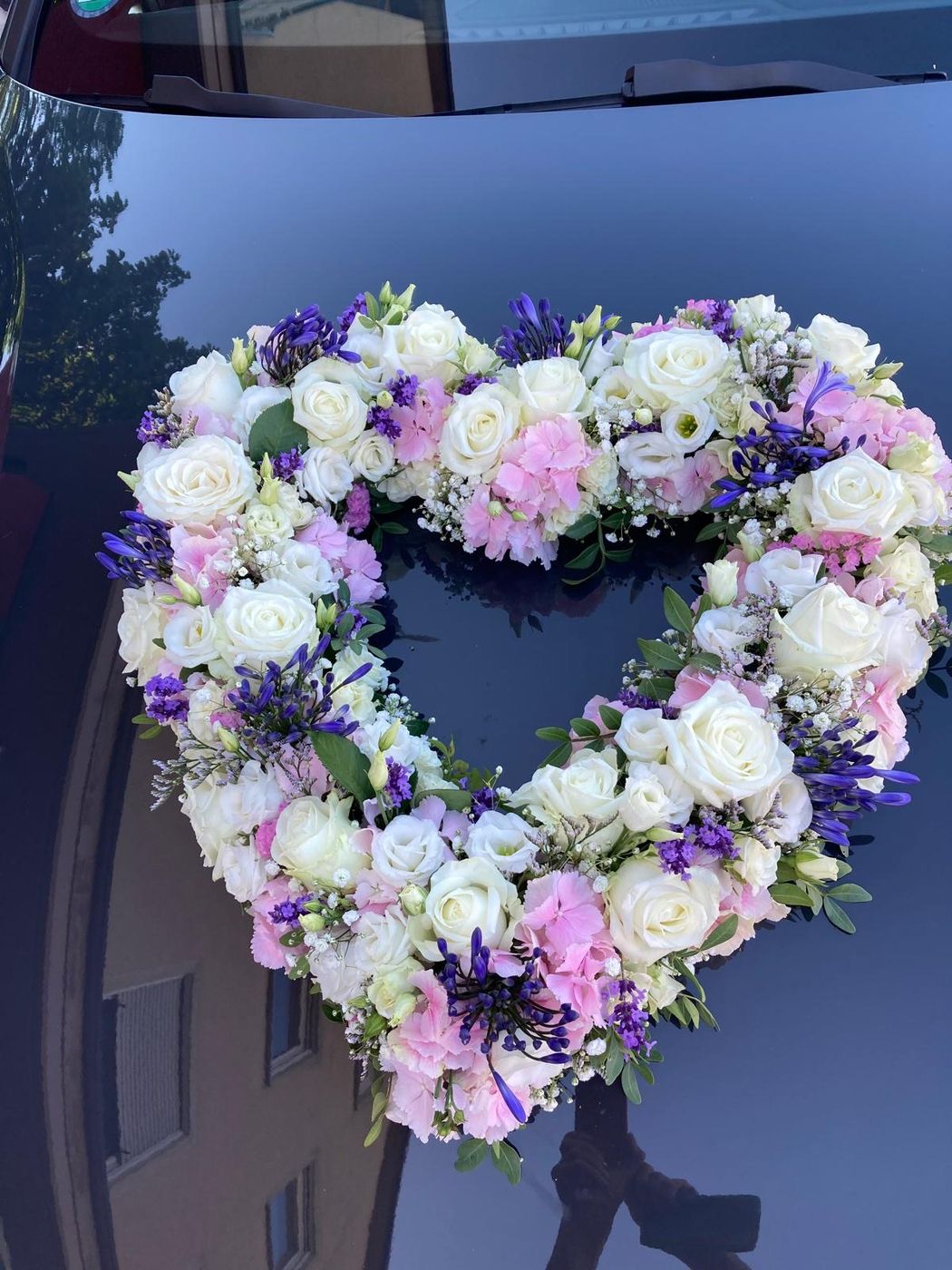 Herz aus Blüten am Hochzeitsauto
