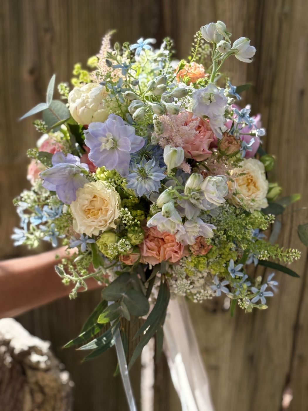 Brautstrauß in Pastelltönen mit Rittersporn, Rosen und Wiesenblumen