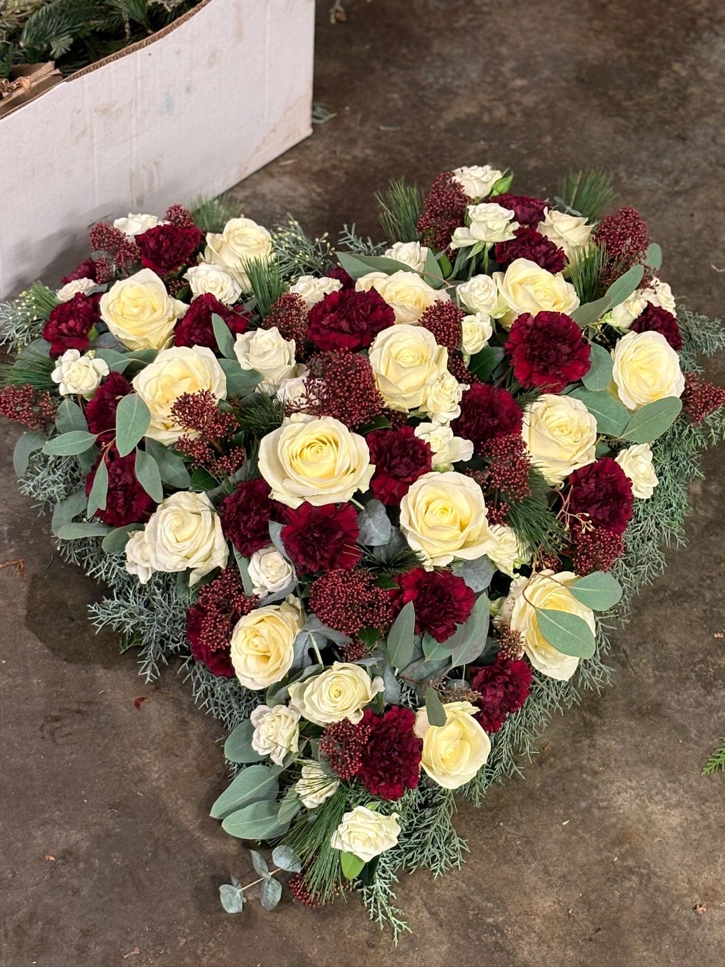 Trauerherz mit roten und weißen Rosen