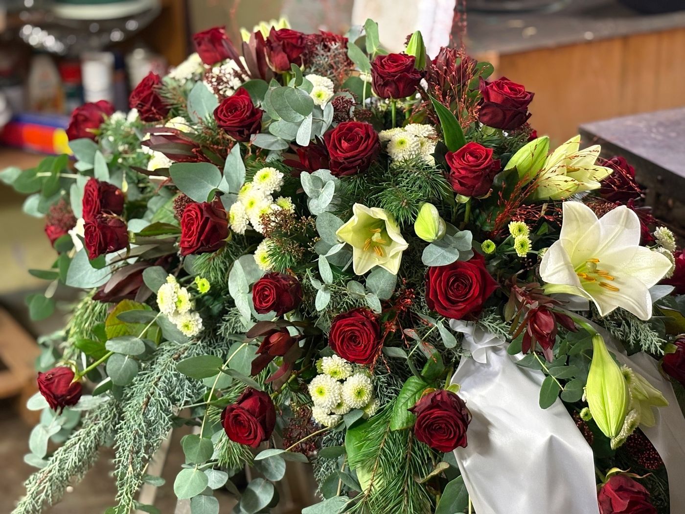 Sargschmuck mit roten und weißen Blumen