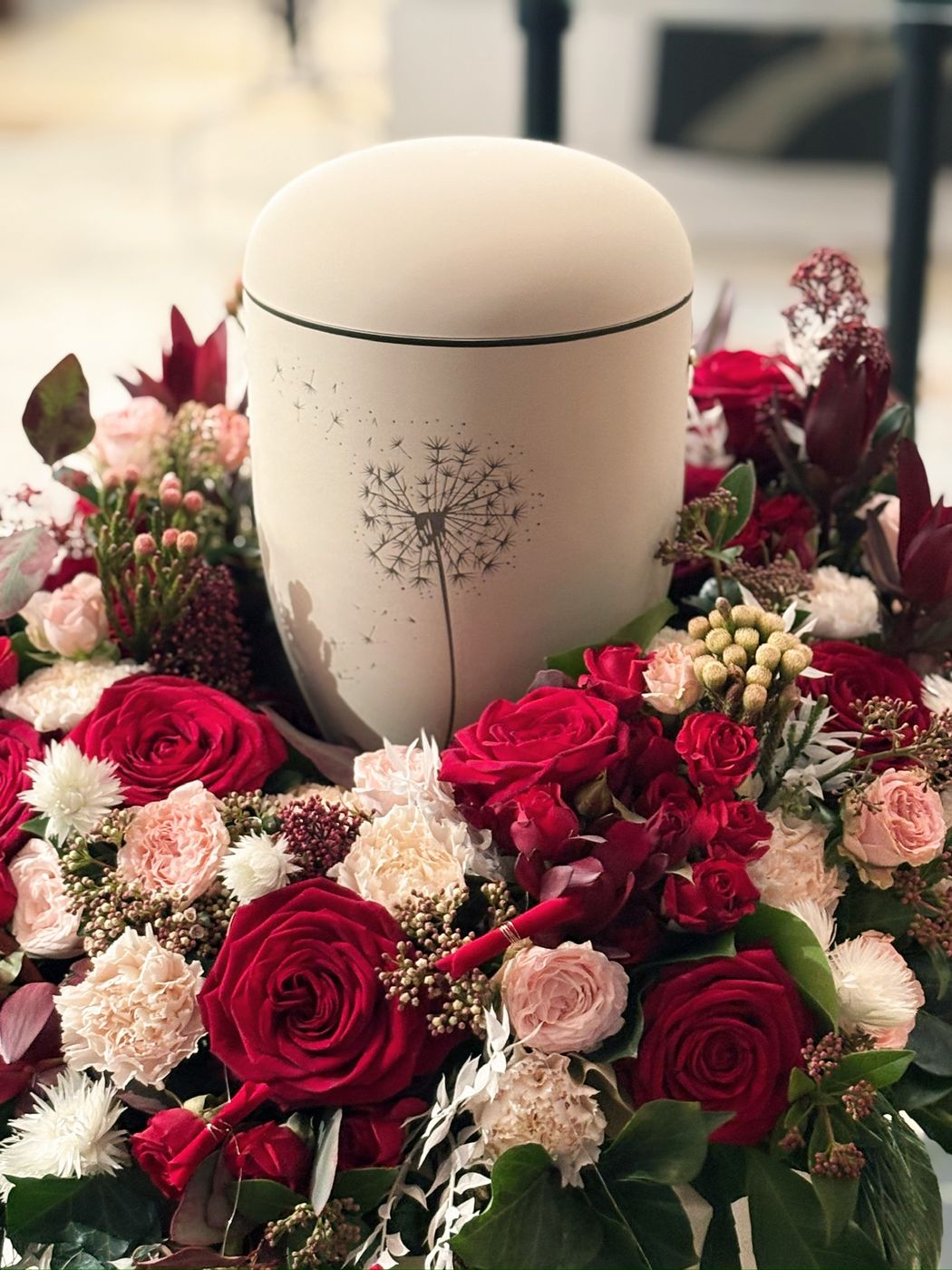 Urnenschmuck mit roten Blüten